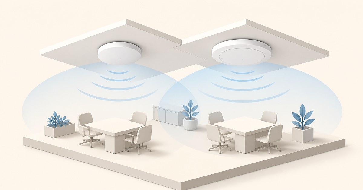 Two ceiling-mounted Wi-Fi access points of different sizes project overlapping blue coverage zones above minimalist office meeting areas.